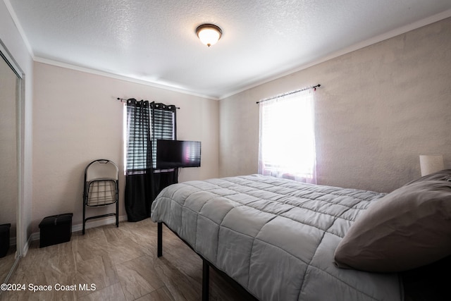 bedroom featuring crown molding and a textured ceiling