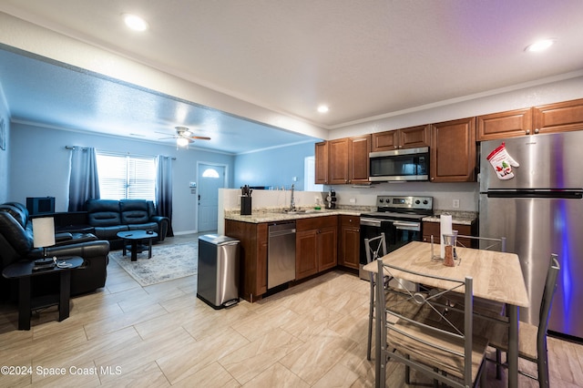 kitchen featuring sink, ceiling fan, ornamental molding, kitchen peninsula, and stainless steel appliances