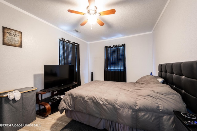 bedroom with a textured ceiling, light hardwood / wood-style floors, ceiling fan, and ornamental molding