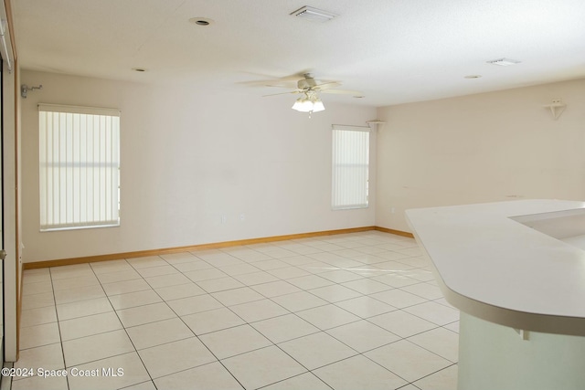 tiled spare room featuring ceiling fan