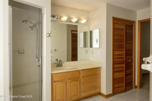 bathroom with tile patterned flooring, vanity, and a shower with door