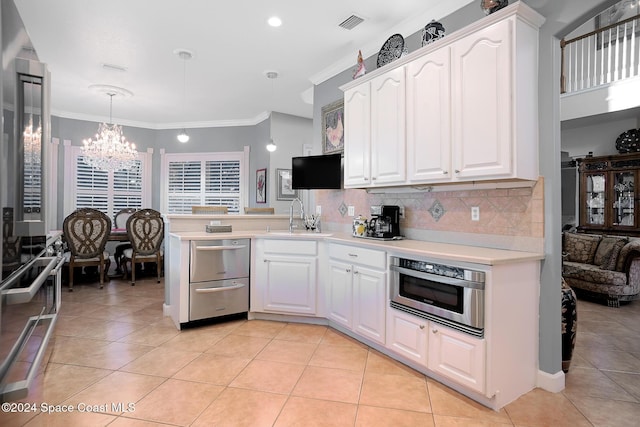 kitchen with decorative light fixtures, white cabinetry, and sink