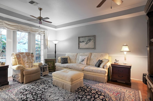 living room with crown molding, ceiling fan, and wood-type flooring