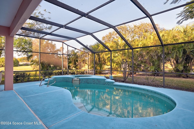 view of swimming pool with an in ground hot tub, a patio area, and a lanai