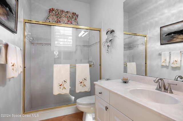 bathroom with tile patterned flooring, vanity, toilet, and walk in shower