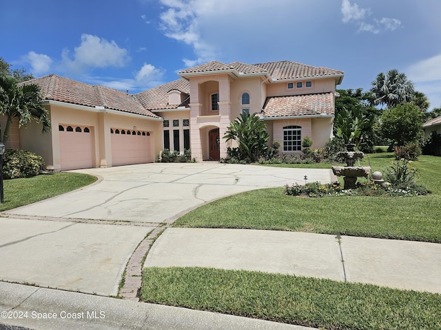 mediterranean / spanish-style home featuring a garage and a front yard