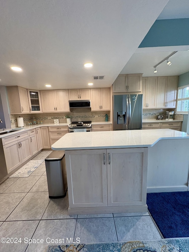 kitchen featuring a kitchen island, light tile patterned floors, range hood, and appliances with stainless steel finishes