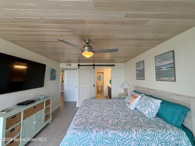 bedroom featuring light tile patterned floors, a barn door, ceiling fan, and wood ceiling