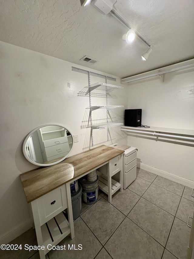 interior space with tile patterned floors and a textured ceiling