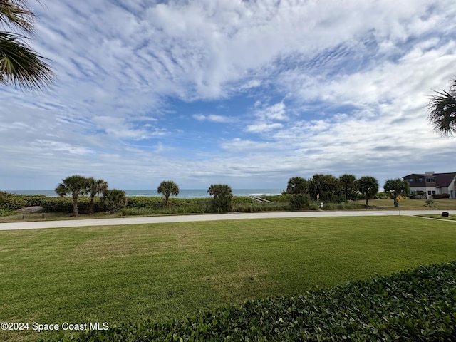 view of home's community with a water view and a yard