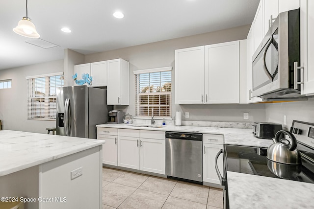 kitchen with white cabinets, appliances with stainless steel finishes, a wealth of natural light, and sink