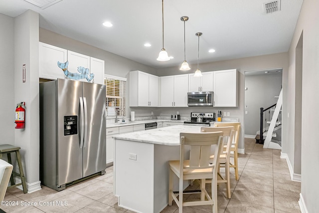 kitchen featuring a center island, white cabinets, sink, light stone counters, and stainless steel appliances