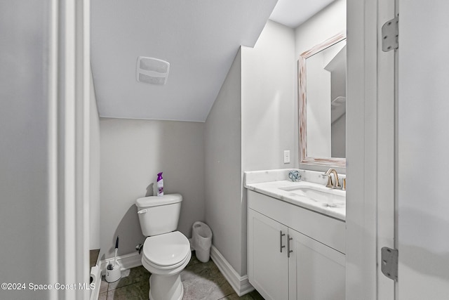 bathroom with tile patterned flooring, vanity, toilet, and vaulted ceiling