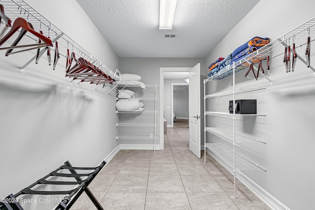 spacious closet featuring tile patterned flooring