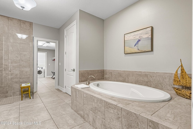 bathroom with tile patterned floors, washer / clothes dryer, and separate shower and tub