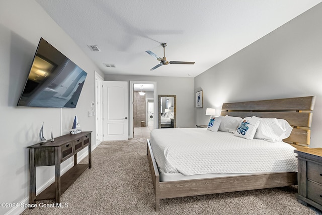 bedroom with ceiling fan, carpet floors, and a textured ceiling