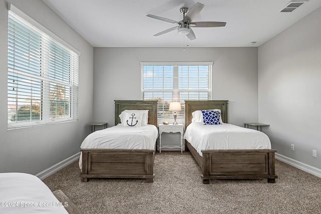 bedroom featuring ceiling fan, carpet floors, and multiple windows