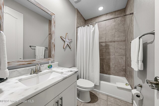 full bathroom featuring tile patterned floors, vanity, toilet, and shower / tub combo