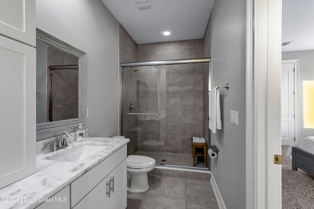 bathroom with toilet, tile patterned flooring, vanity, and walk in shower