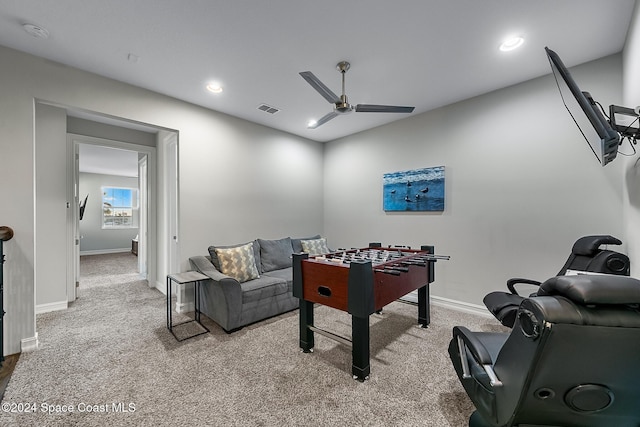 game room with ceiling fan and light carpet