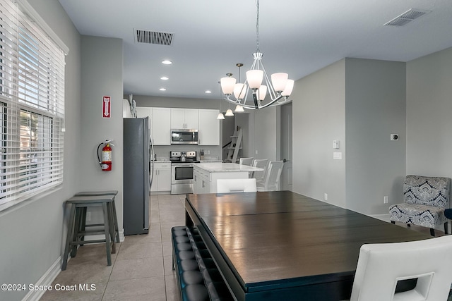 dining space featuring light tile patterned floors and a notable chandelier