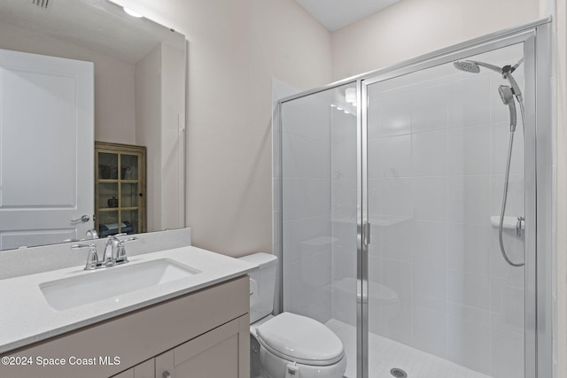 bathroom featuring vanity, toilet, and a shower with door