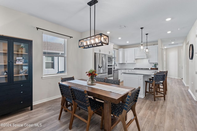 dining area featuring light wood-type flooring and sink