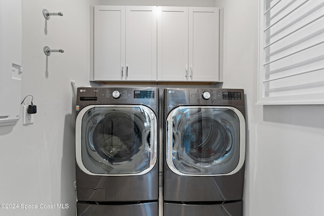 laundry area with cabinets and washing machine and dryer