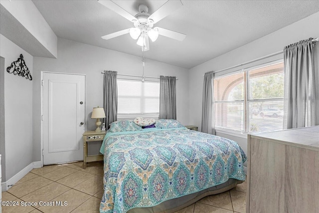 bedroom featuring tile patterned floors, ceiling fan, lofted ceiling, and multiple windows