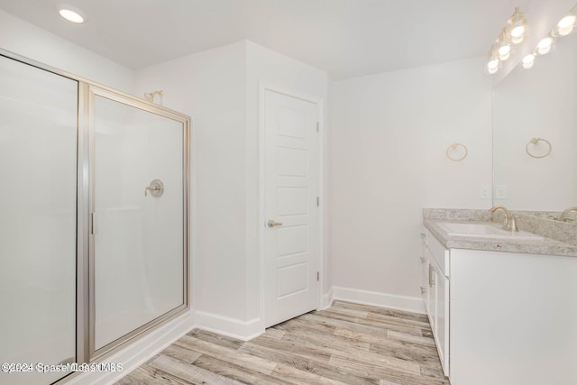 bathroom featuring hardwood / wood-style floors, vanity, and an enclosed shower