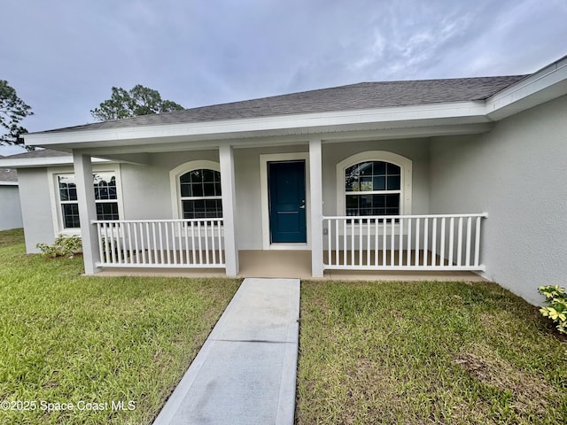725 De Groodt Rd SW, Palm Bay, FL 32908 - entrance to property with stucco siding, covered porch, roof with shingles, and a yard