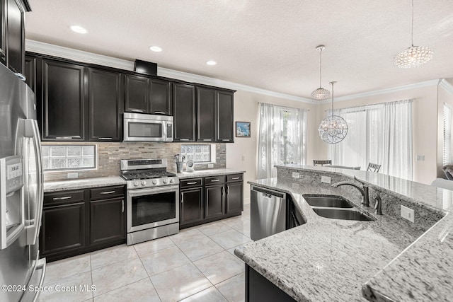 kitchen with sink, stainless steel appliances, an inviting chandelier, crown molding, and pendant lighting