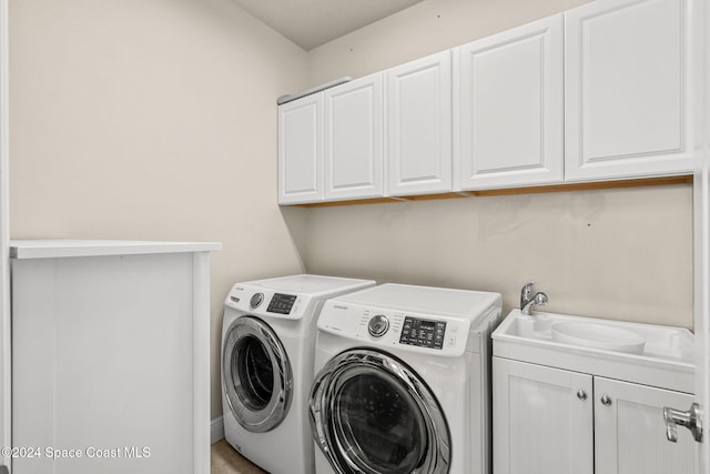 laundry room with washer and dryer, cabinets, and sink