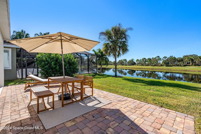 view of patio with glass enclosure and a water view