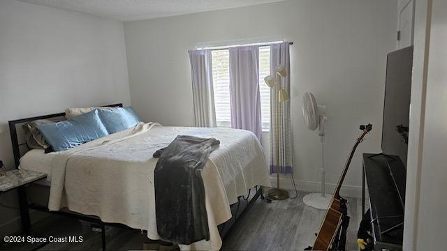 bedroom with dark hardwood / wood-style flooring and a textured ceiling