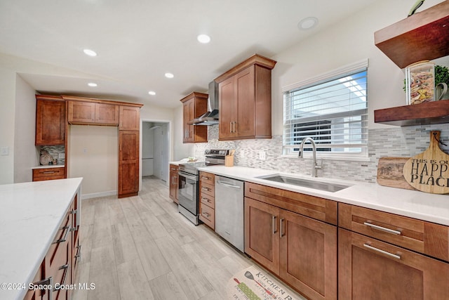 kitchen with sink, wall chimney exhaust hood, light wood-type flooring, appliances with stainless steel finishes, and tasteful backsplash