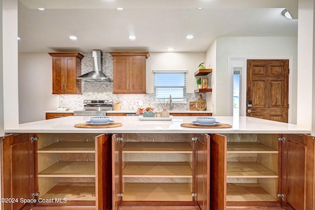 kitchen with a center island, light stone counters, wall chimney range hood, and electric stove