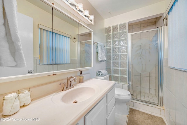 bathroom featuring tile patterned flooring, vanity, a shower with shower door, and toilet