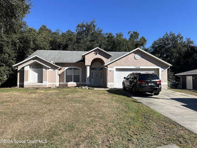 7444 Glenwood Rd, Cocoa, FL 32927 - ranch-style house with driveway, a front lawn, an attached garage, and stucco siding