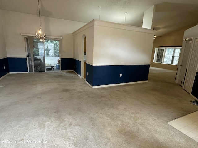7444 Glenwood Rd, Cocoa, FL 32927 - empty room with lofted ceiling, carpet floors, plenty of natural light, and a chandelier
