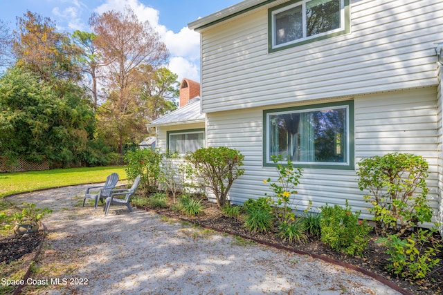 view of property exterior featuring a patio area and a yard