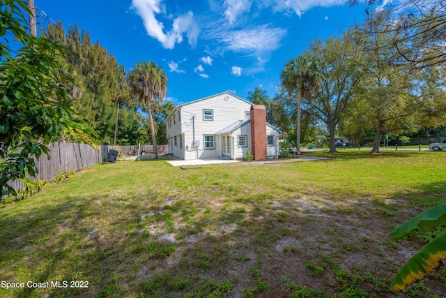 rear view of house with a yard and a patio