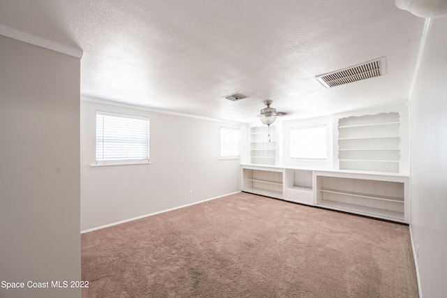 unfurnished living room featuring carpet flooring, crown molding, and a textured ceiling