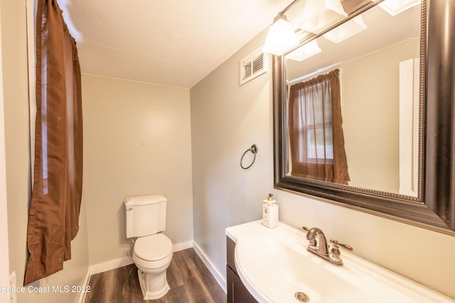 bathroom with hardwood / wood-style floors, vanity, and toilet