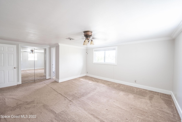 unfurnished room featuring crown molding, carpet, and ceiling fan