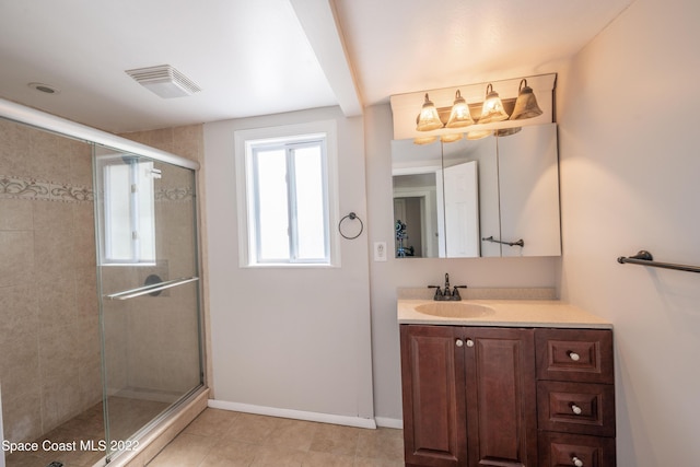 bathroom with tile patterned flooring, vanity, and walk in shower