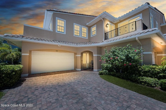 mediterranean / spanish house featuring a balcony and a garage