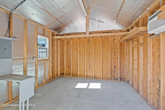 storage room featuring an AC wall unit and electric panel