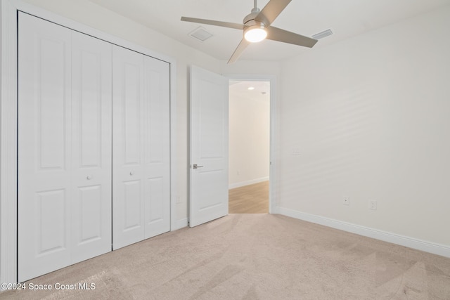 unfurnished bedroom featuring ceiling fan, light carpet, and a closet