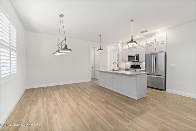 kitchen featuring sink, white cabinetry, stainless steel appliances, and a wealth of natural light